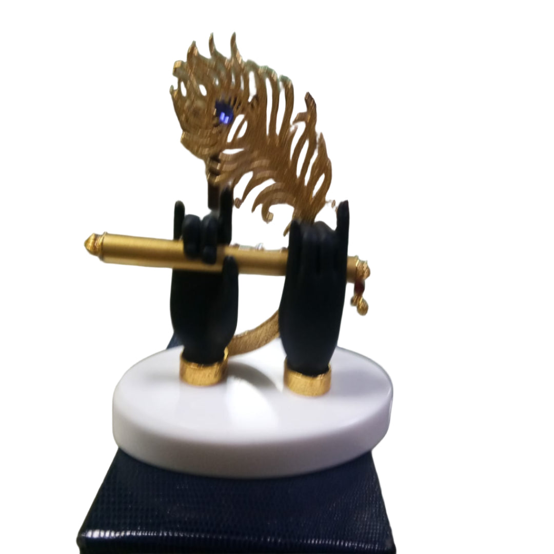 Decorative item with black hands holding a golden staff on a white base, set against a blurred indoor background.