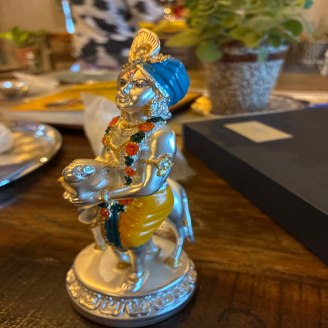 Decorative statue of a figure with a blue turban and colorful attire on a wooden surface.