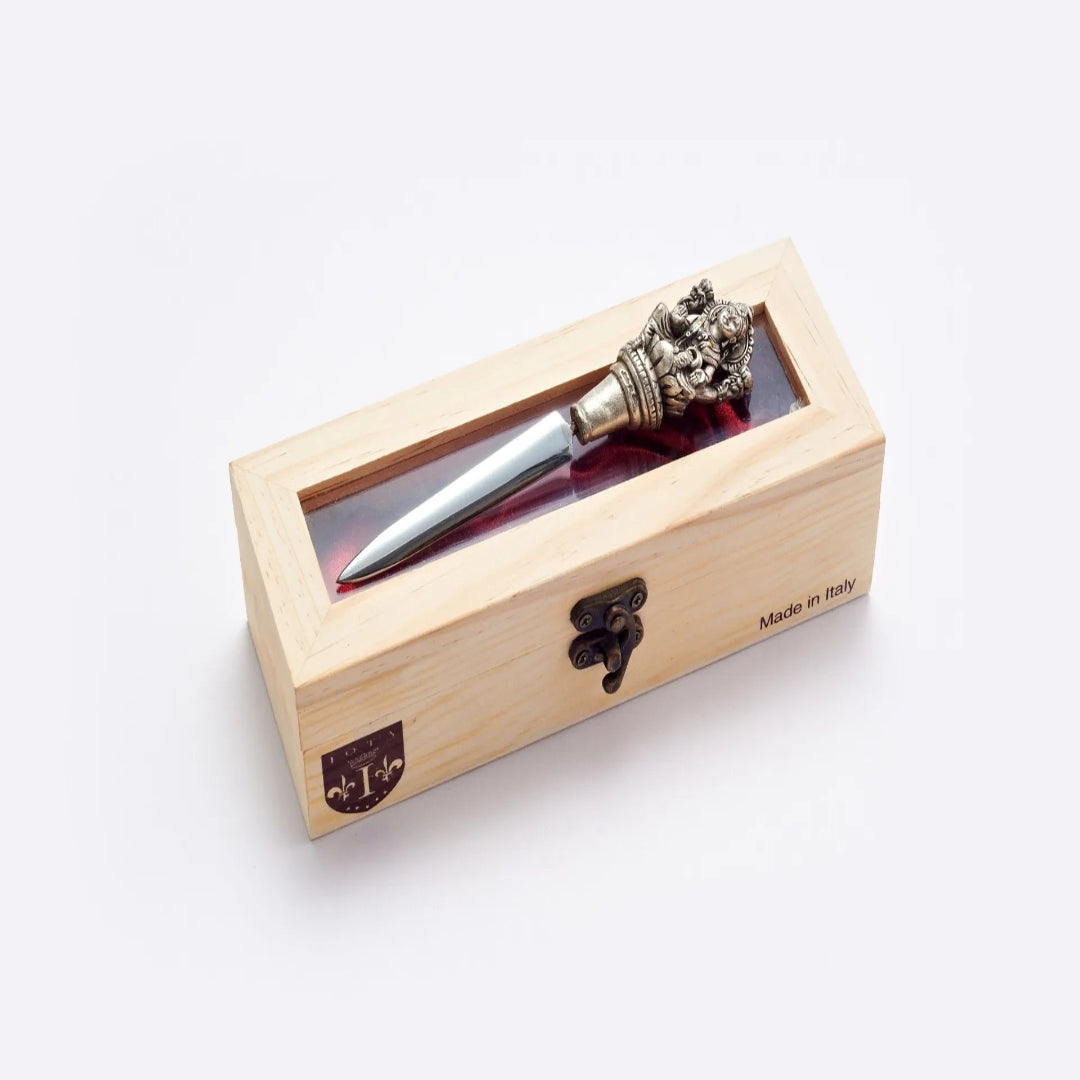 Decorative pen with ornate top in a wooden box on a white background